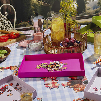 Puzzle Sorting Trays from Piecework Puzzles shown in a table scene with refreshments and partially done puzzle. Stop motion animation shows the use of the puzzle tray for sorting puzzle pieces.