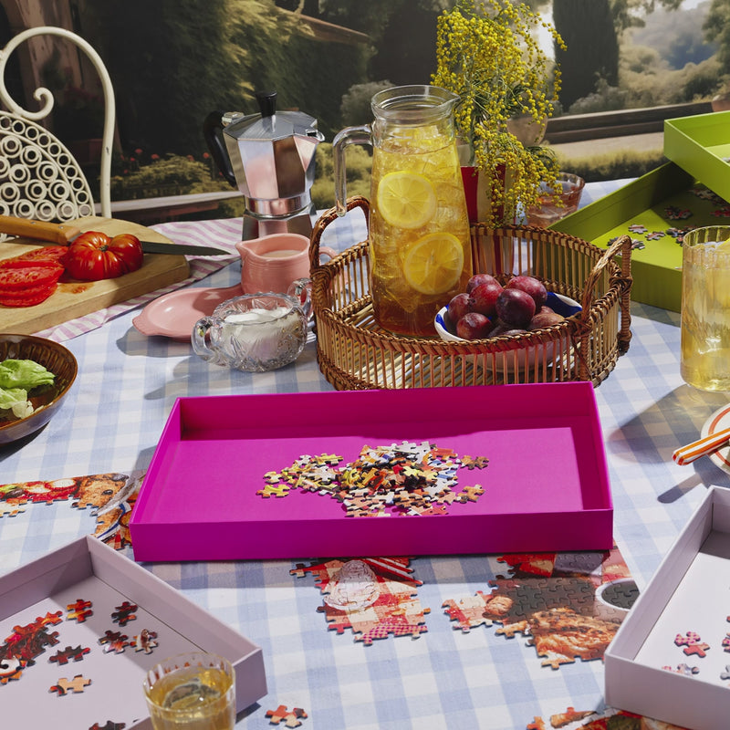 Puzzle Sorting Trays from Piecework Puzzles shown in a table scene with refreshments and partially done puzzle. Stop motion animation shows the use of the puzzle tray for sorting puzzle pieces.
