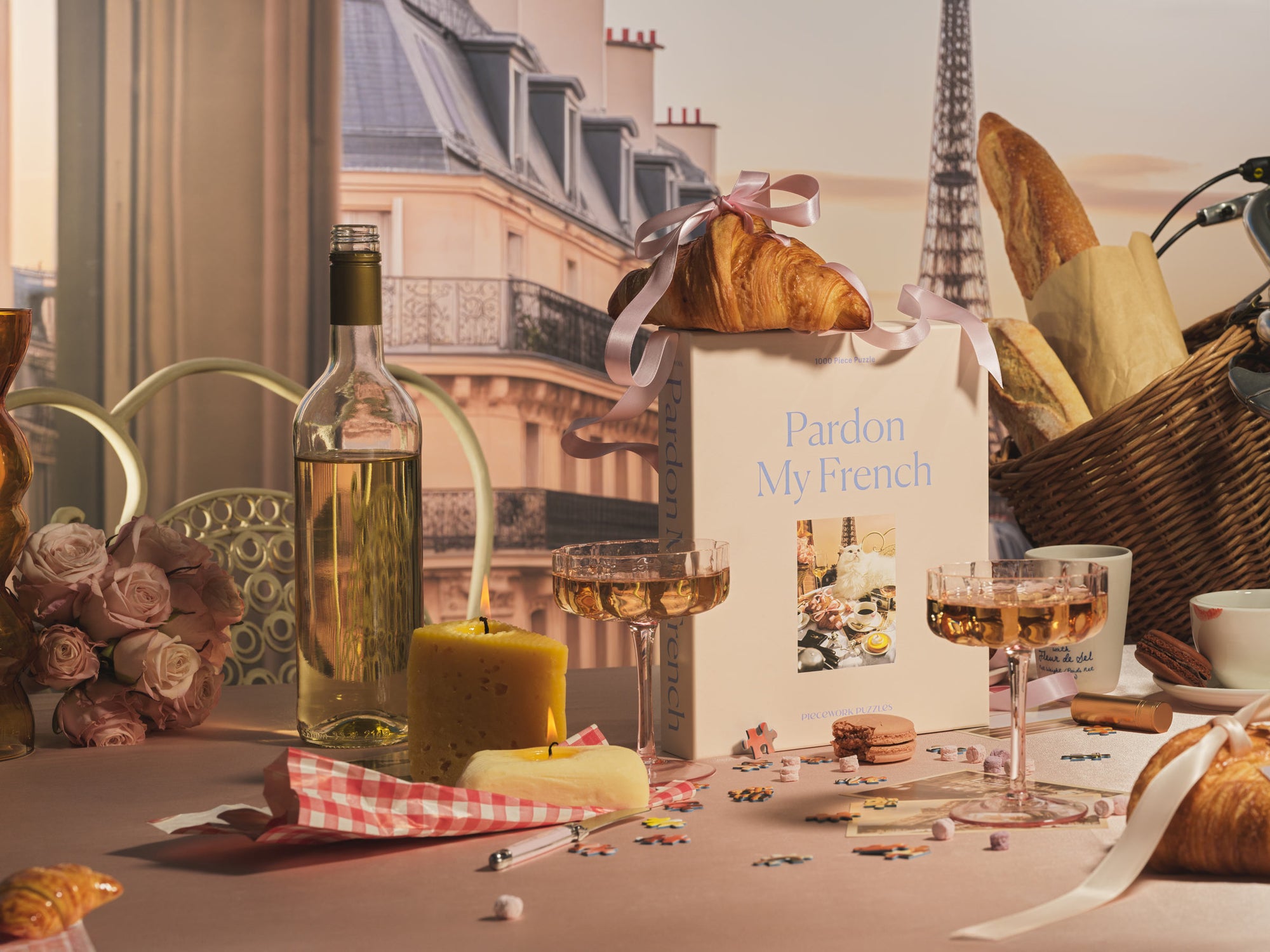 A scene of gifts from the Frenchie Edit, including Pardon My French Puzzle, Cheese Candle, Butter Candle, and Champagne Glasses.